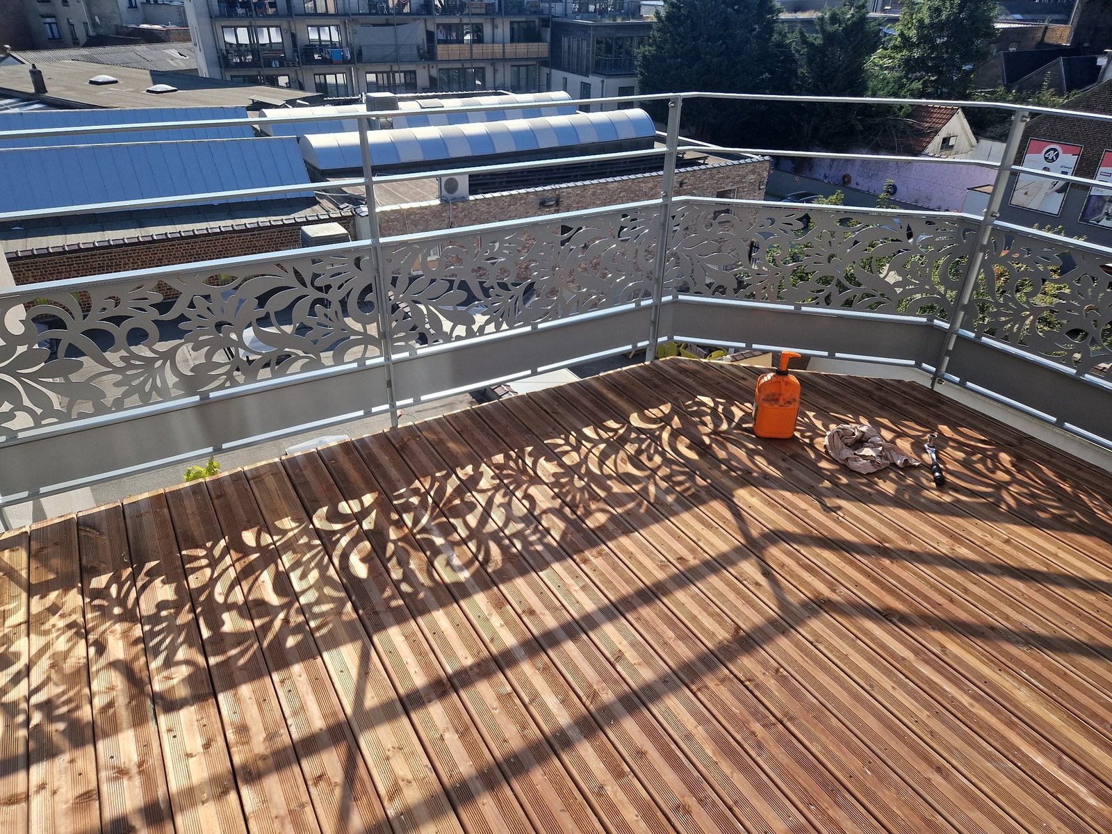 Garde-corps découpé au laser, motif floral, et terrasse en bois
